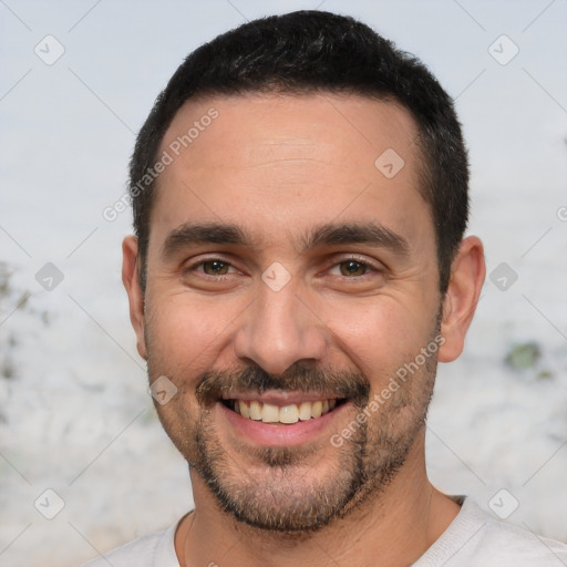 Joyful white young-adult male with short  black hair and brown eyes