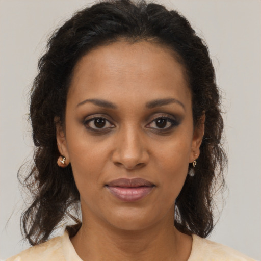 Joyful black young-adult female with medium  brown hair and brown eyes