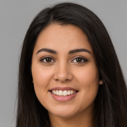 Joyful latino young-adult female with long  brown hair and brown eyes