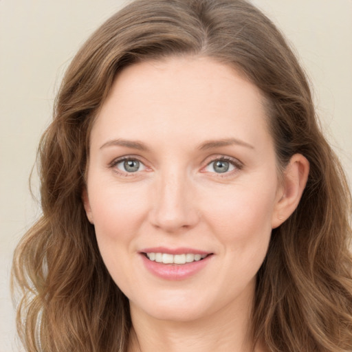 Joyful white young-adult female with long  brown hair and blue eyes