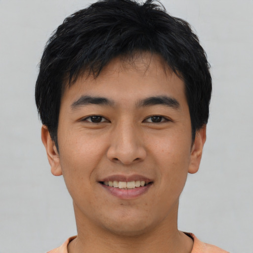 Joyful asian young-adult male with short  black hair and brown eyes