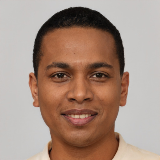 Joyful black young-adult male with short  black hair and brown eyes