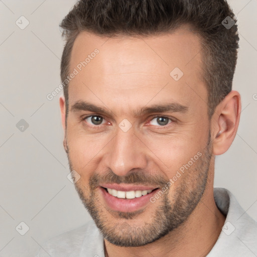 Joyful white young-adult male with short  brown hair and brown eyes