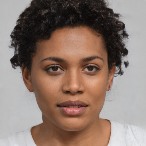 Joyful black young-adult female with short  black hair and brown eyes