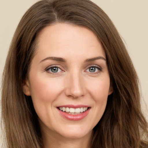 Joyful white young-adult female with long  brown hair and green eyes