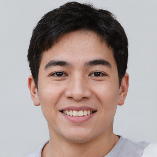 Joyful asian young-adult male with short  brown hair and brown eyes
