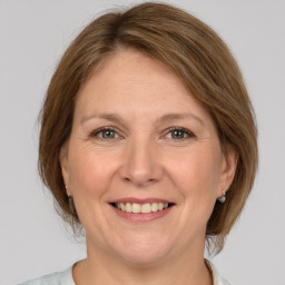 Joyful white adult female with medium  brown hair and grey eyes