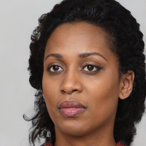 Joyful black young-adult female with long  black hair and brown eyes
