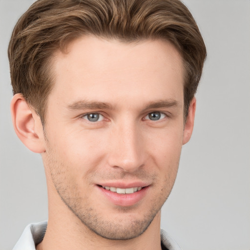 Joyful white young-adult male with short  brown hair and grey eyes