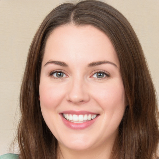 Joyful white young-adult female with long  brown hair and green eyes