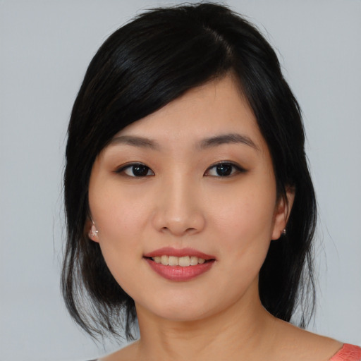 Joyful asian young-adult female with medium  black hair and brown eyes