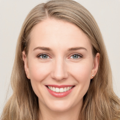 Joyful white young-adult female with long  brown hair and blue eyes