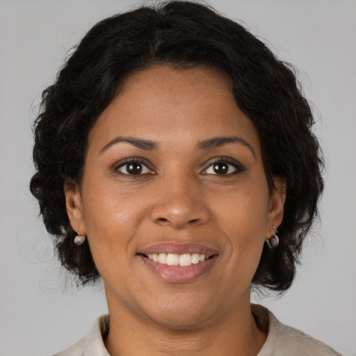 Joyful black adult female with medium  brown hair and brown eyes