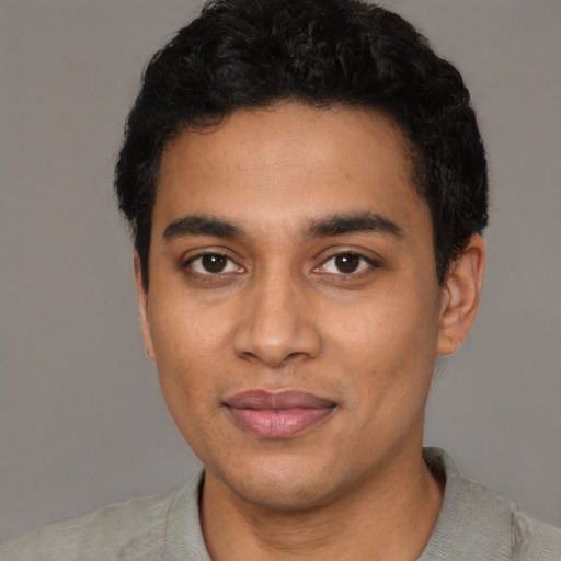 Joyful latino young-adult male with short  black hair and brown eyes