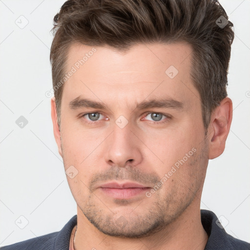 Joyful white young-adult male with short  brown hair and grey eyes