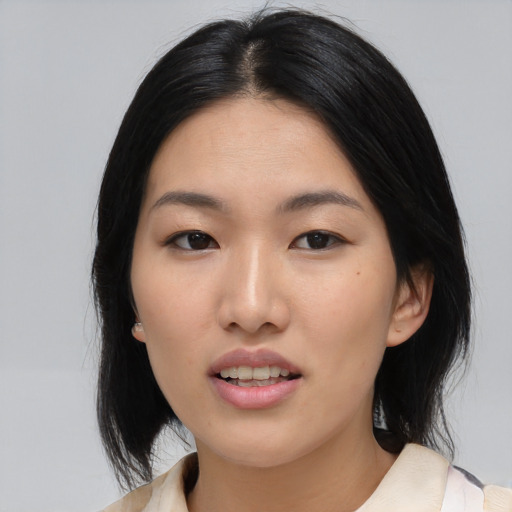 Joyful asian young-adult female with medium  black hair and brown eyes