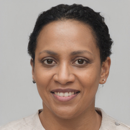 Joyful black young-adult female with short  brown hair and brown eyes