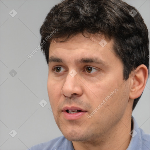 Joyful white young-adult male with short  black hair and brown eyes