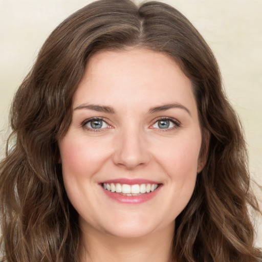 Joyful white young-adult female with long  brown hair and green eyes