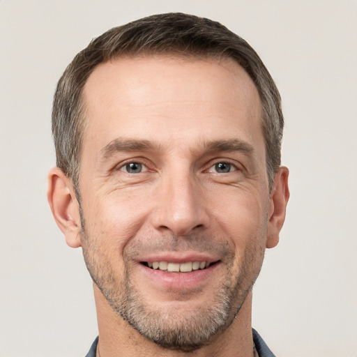 Joyful white adult male with short  brown hair and grey eyes