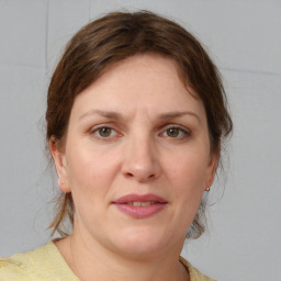 Joyful white young-adult female with medium  brown hair and grey eyes