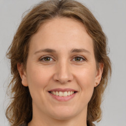 Joyful white young-adult female with medium  brown hair and green eyes