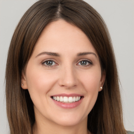 Joyful white young-adult female with long  brown hair and brown eyes