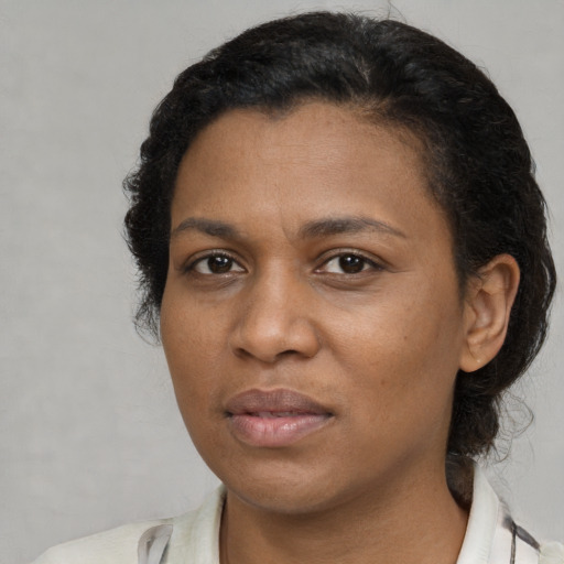 Joyful black adult female with short  brown hair and brown eyes