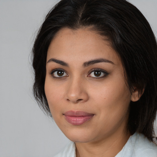 Joyful latino young-adult female with medium  brown hair and brown eyes