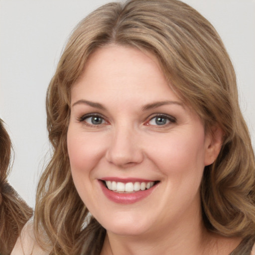 Joyful white young-adult female with medium  brown hair and blue eyes