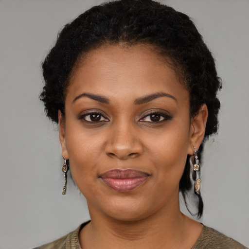 Joyful black young-adult female with short  black hair and brown eyes