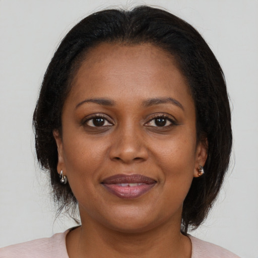 Joyful black adult female with medium  brown hair and brown eyes