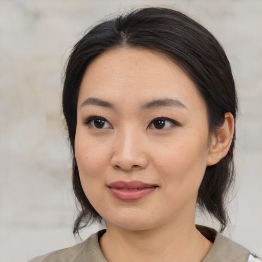 Joyful asian young-adult female with medium  black hair and brown eyes