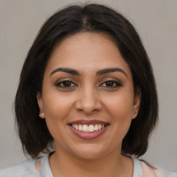 Joyful latino young-adult female with medium  brown hair and brown eyes