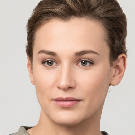 Joyful white young-adult female with short  brown hair and grey eyes