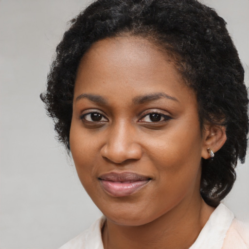Joyful black young-adult female with medium  black hair and brown eyes