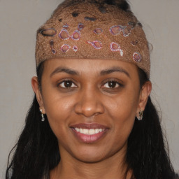 Joyful black young-adult female with long  brown hair and brown eyes