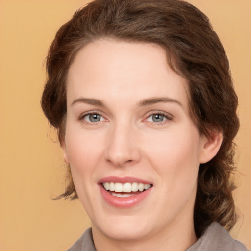 Joyful white young-adult female with medium  brown hair and green eyes