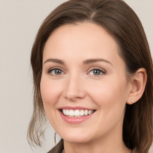 Joyful white young-adult female with medium  brown hair and grey eyes