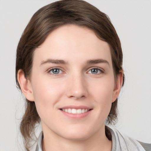 Joyful white young-adult female with medium  brown hair and grey eyes