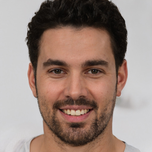 Joyful white young-adult male with short  black hair and brown eyes