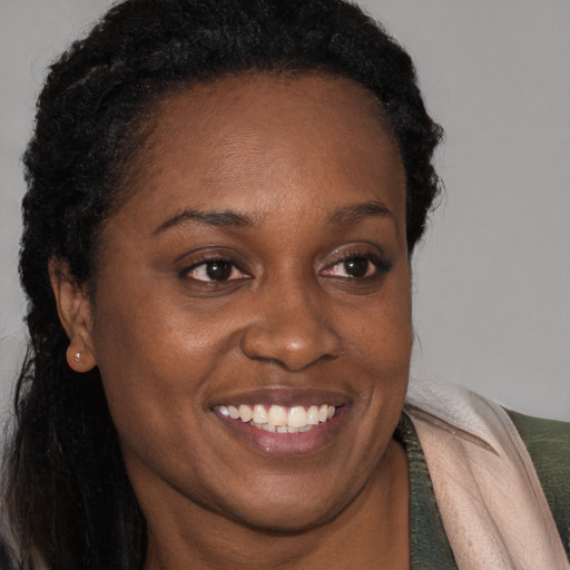 Joyful black young-adult female with long  brown hair and brown eyes