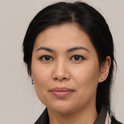 Joyful latino adult female with medium  brown hair and brown eyes