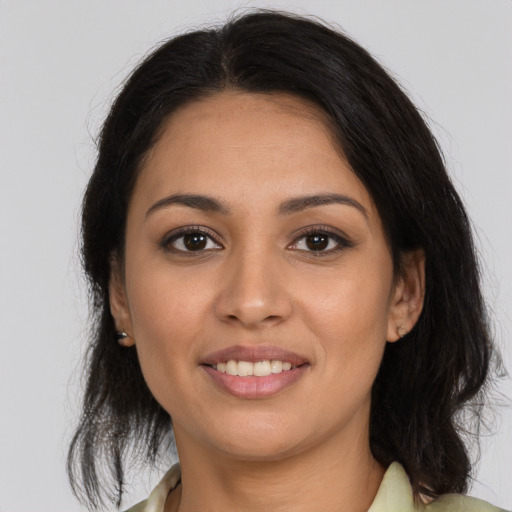 Joyful latino young-adult female with medium  brown hair and brown eyes