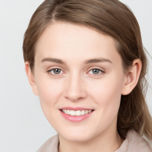 Joyful white young-adult female with medium  brown hair and grey eyes