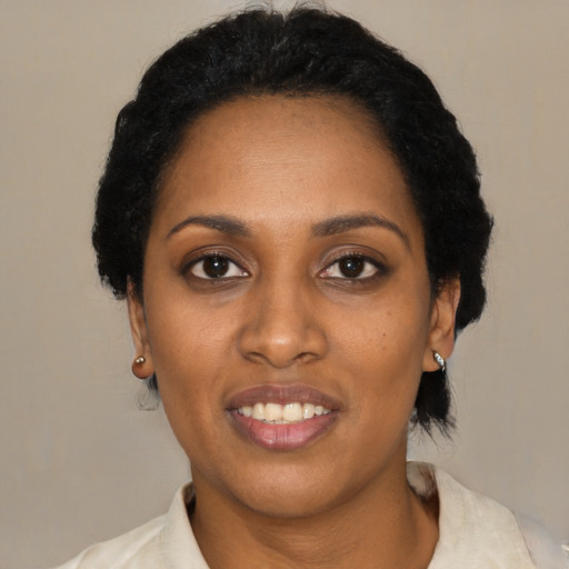Joyful black adult female with medium  black hair and brown eyes