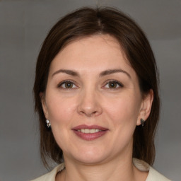 Joyful white adult female with medium  brown hair and brown eyes