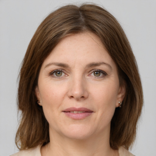 Joyful white young-adult female with medium  brown hair and green eyes