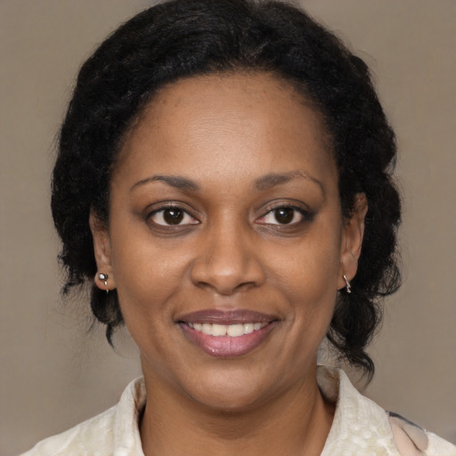 Joyful black adult female with medium  brown hair and brown eyes