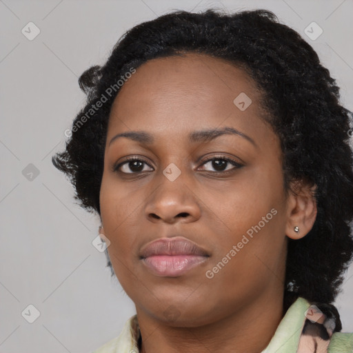 Joyful black young-adult female with long  black hair and brown eyes